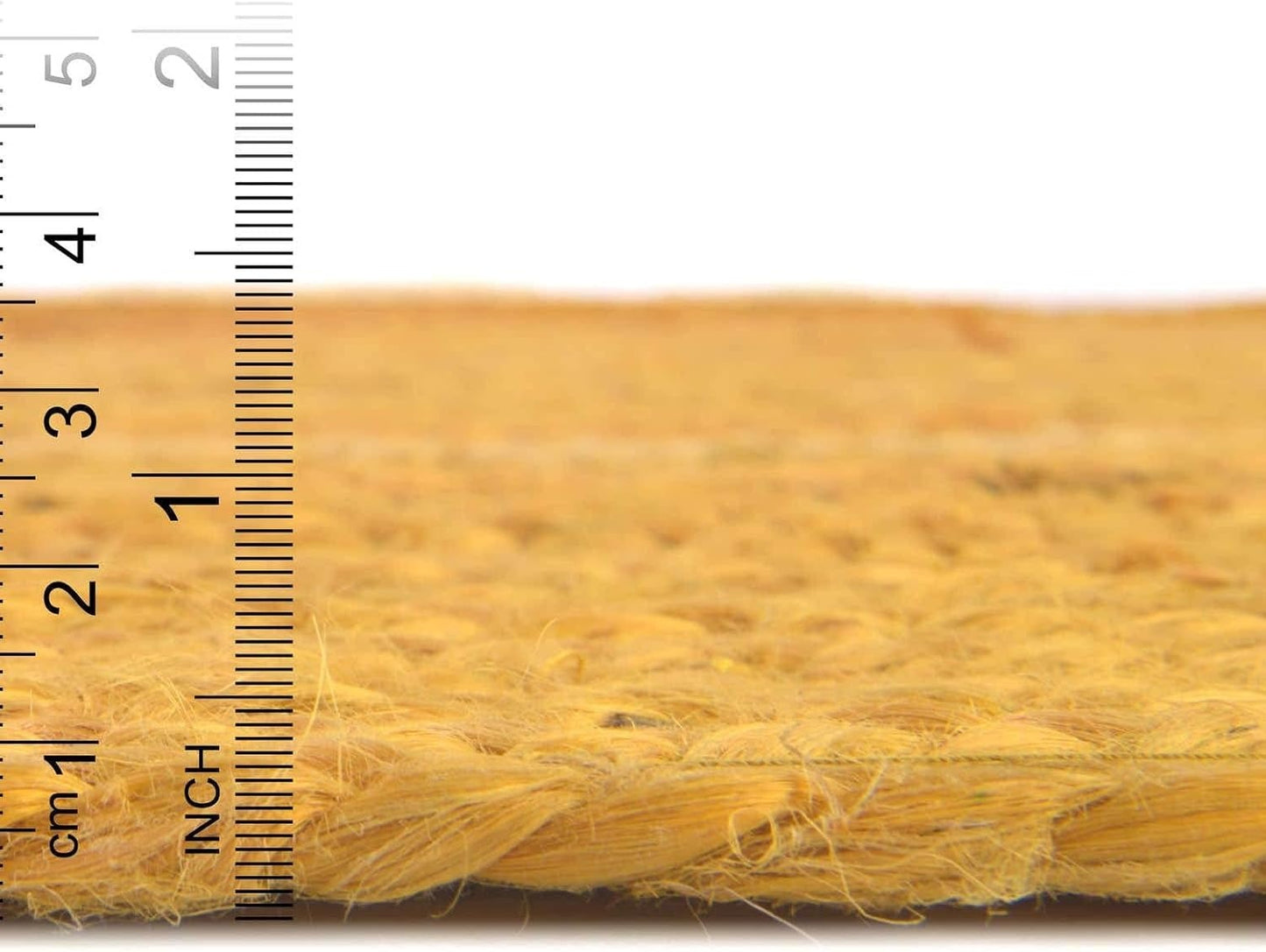 Close-up of a yellow woven mat with a ruler for scale on a white background