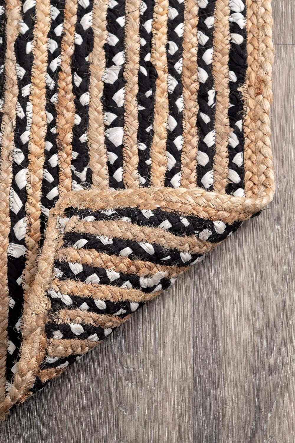 Textured rug with black, white, and beige pattern on a wooden floor