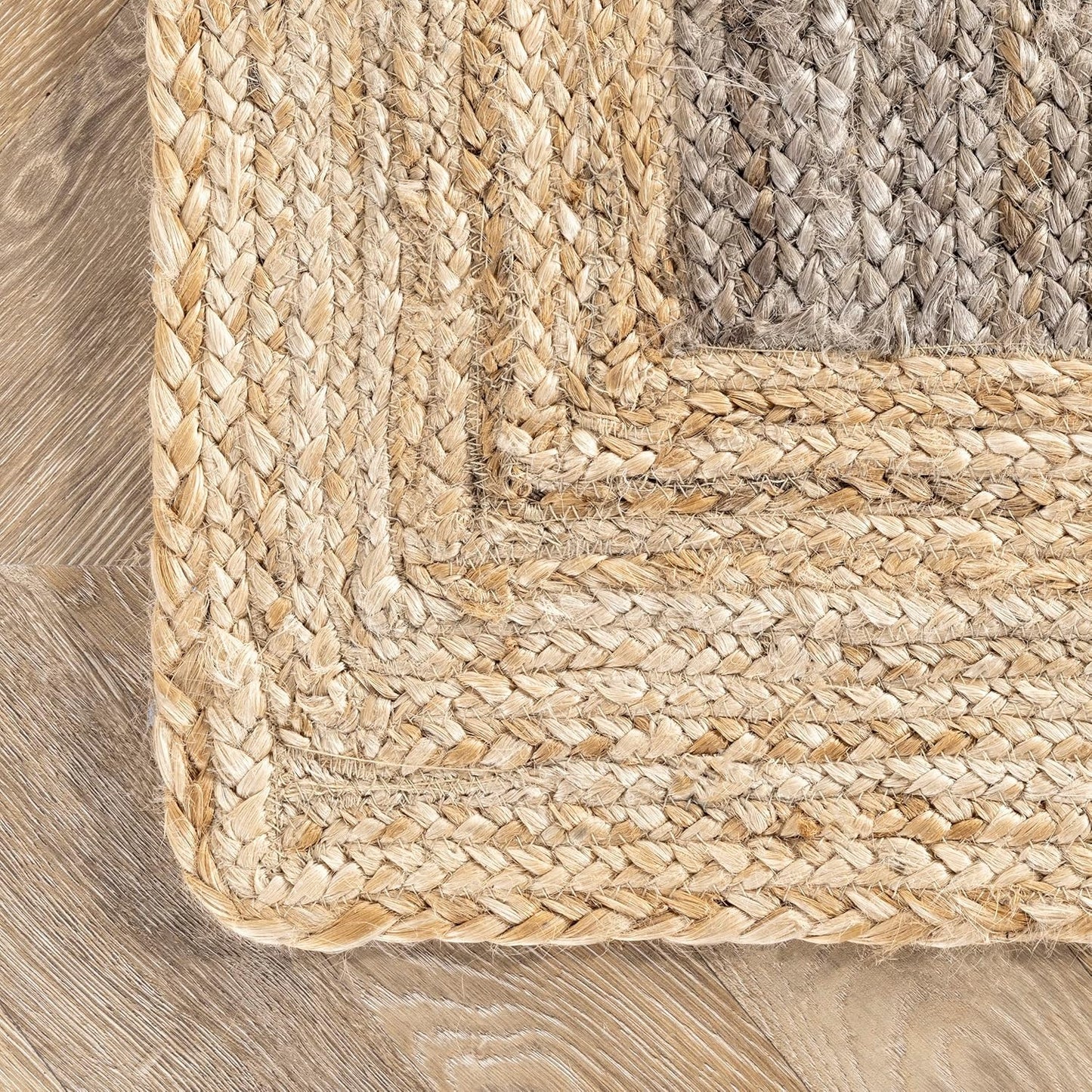 Close-up of a braided rug corner on a wooden floor