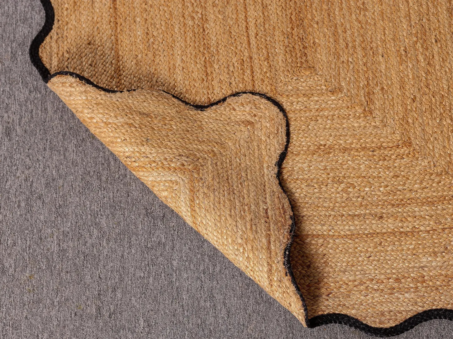Close-up of a brown rug corner on a gray surface