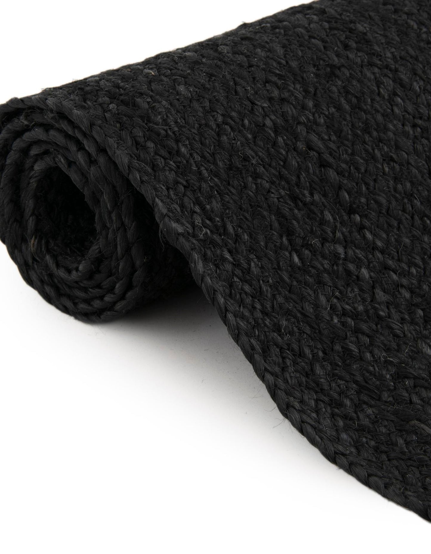 Folded black jute rug showing thickness flexible handmade woven carpet