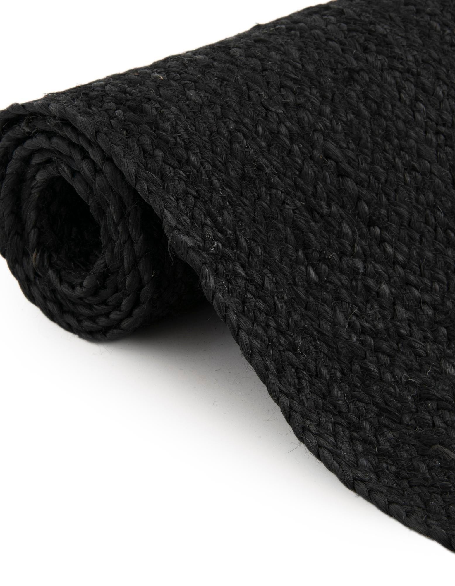 Folded black jute rug showing thickness flexible handmade woven carpet