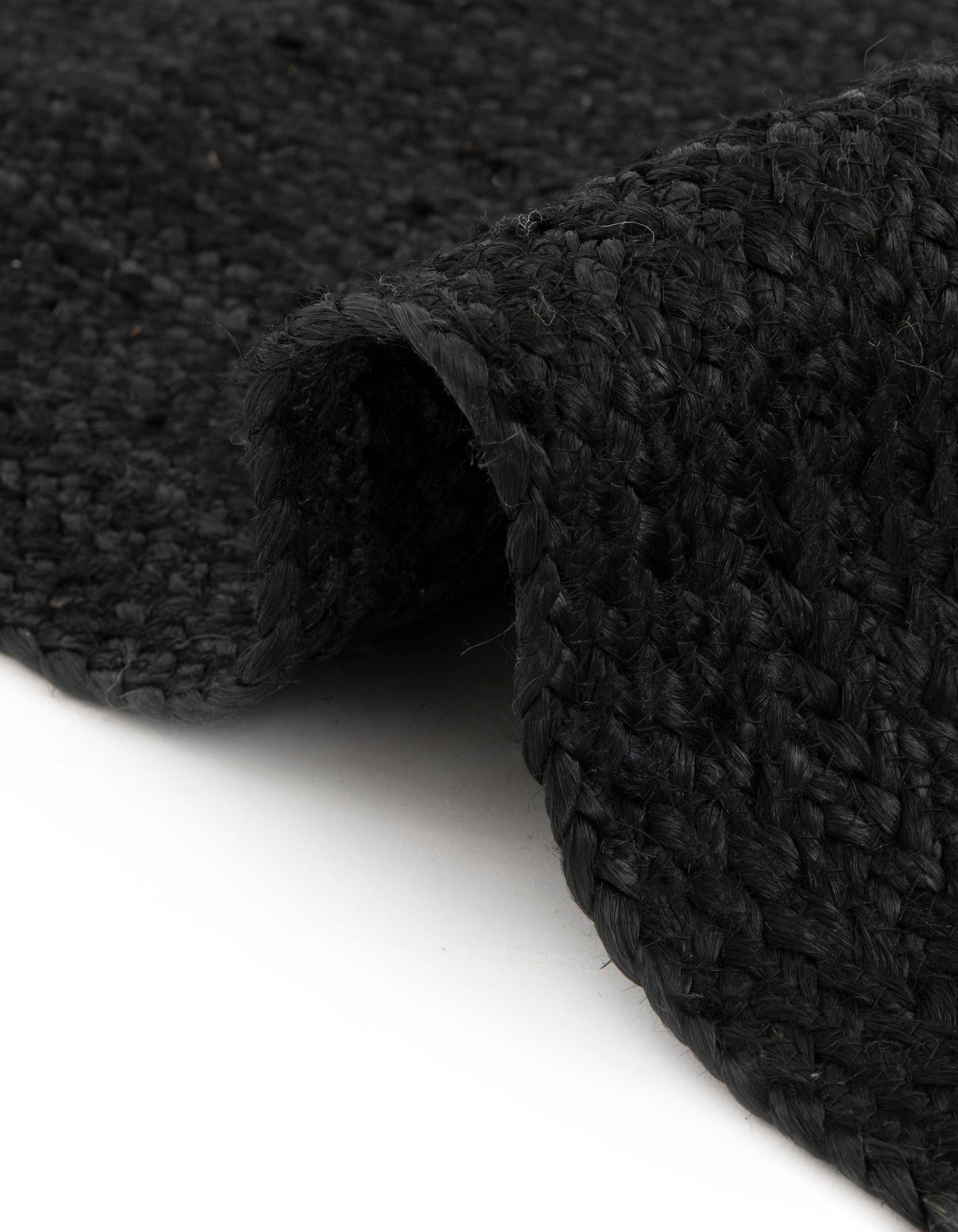 Close-up of a black textured rug on a white background