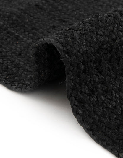 Close-up of a black textured rug on a white background