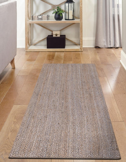 Gray runner rug on a wooden floor with a shelf in the background