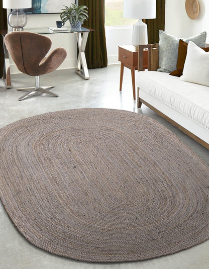 Oval braided rug in a living room setting with a sofa and chair.