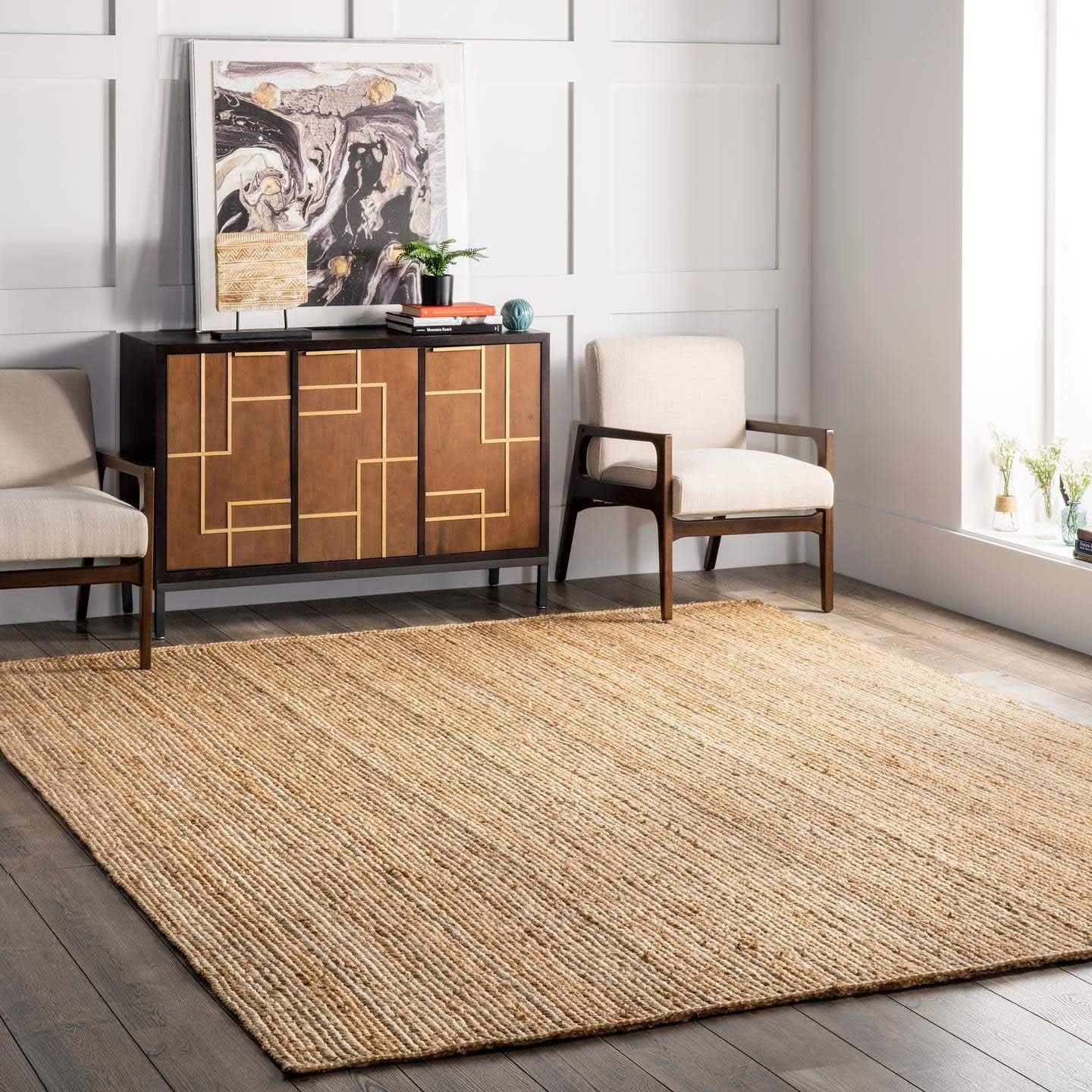 Living room with a textured rug, wooden sideboard, and white walls.