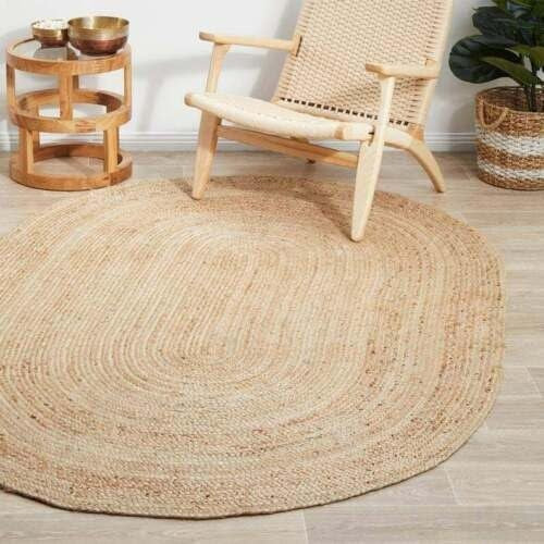 oval jute rug on a wooden floor with a woven chair and side table in the background.