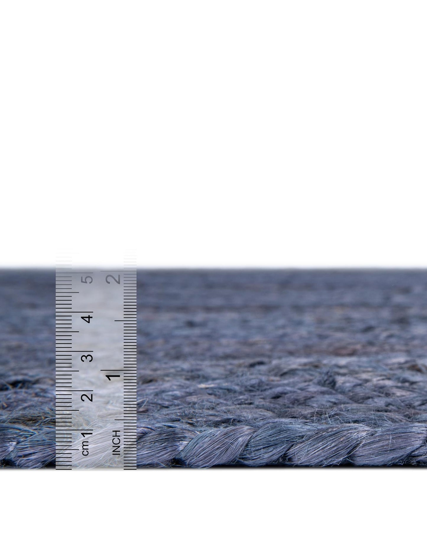 Textured blue carpet with a ruler for scale on a white background