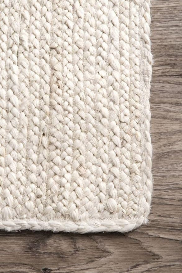 Close-up of a textured beige rug on a wooden floor