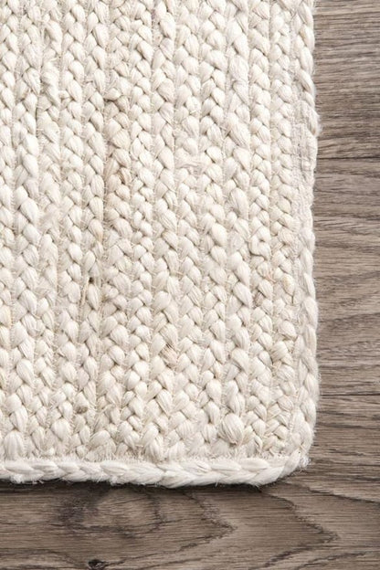 Close-up of a textured beige rug on a wooden floor