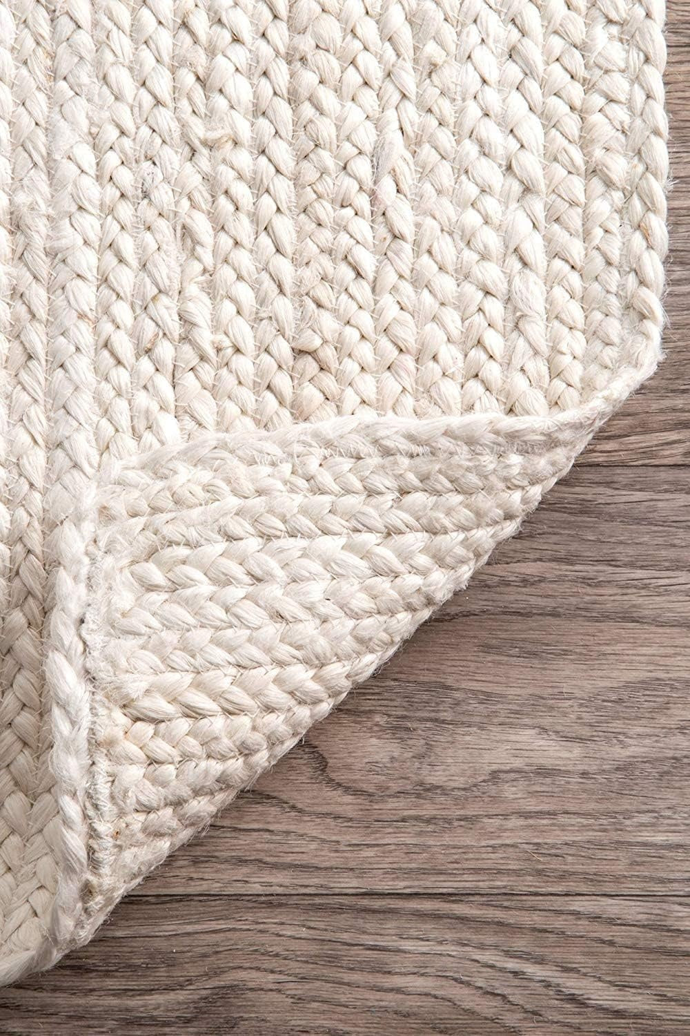 Close-up of a textured beige rug on a wooden floor