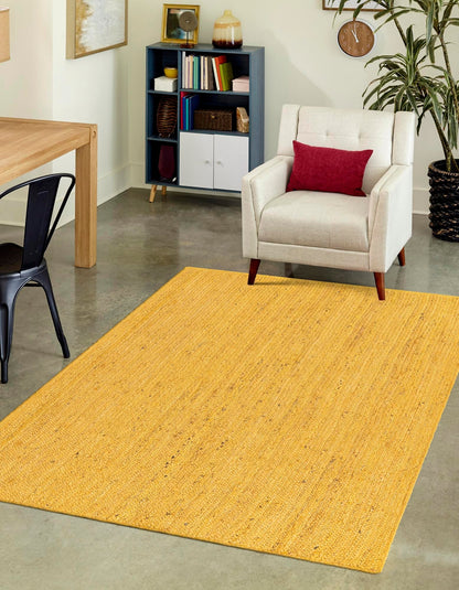 Yellow rug in a living room with a chair and bookshelf.