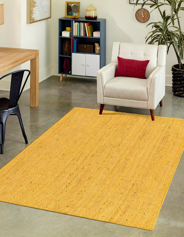 Yellow rug in a living room with a chair and bookshelf.