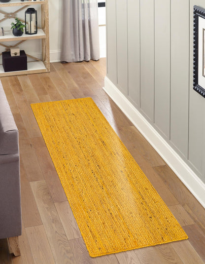 Yellow rug on a wooden floor in a room with a shelf and curtains.