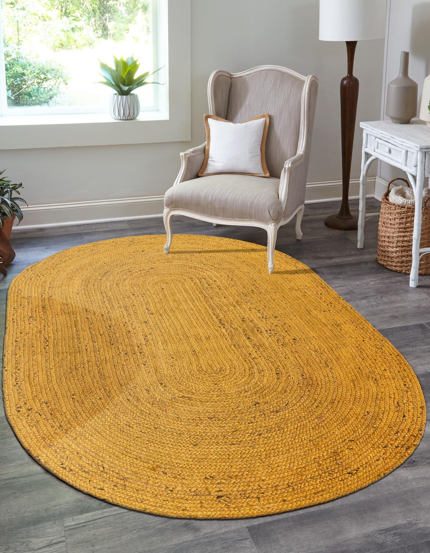 Yellow oval rug in a room with a chair and décor items.