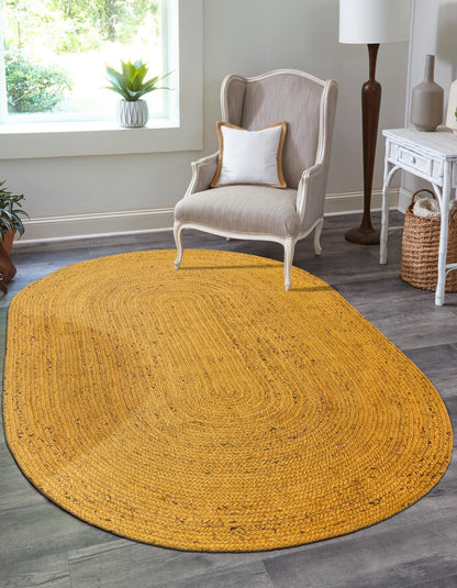 Yellow oval rug in a room with a chair and décor items.