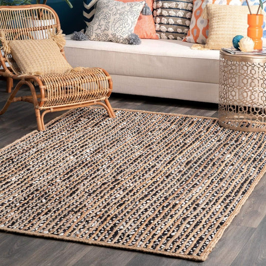 Living room with a woven rug, wicker chair, and colorful cushions on a sofa.