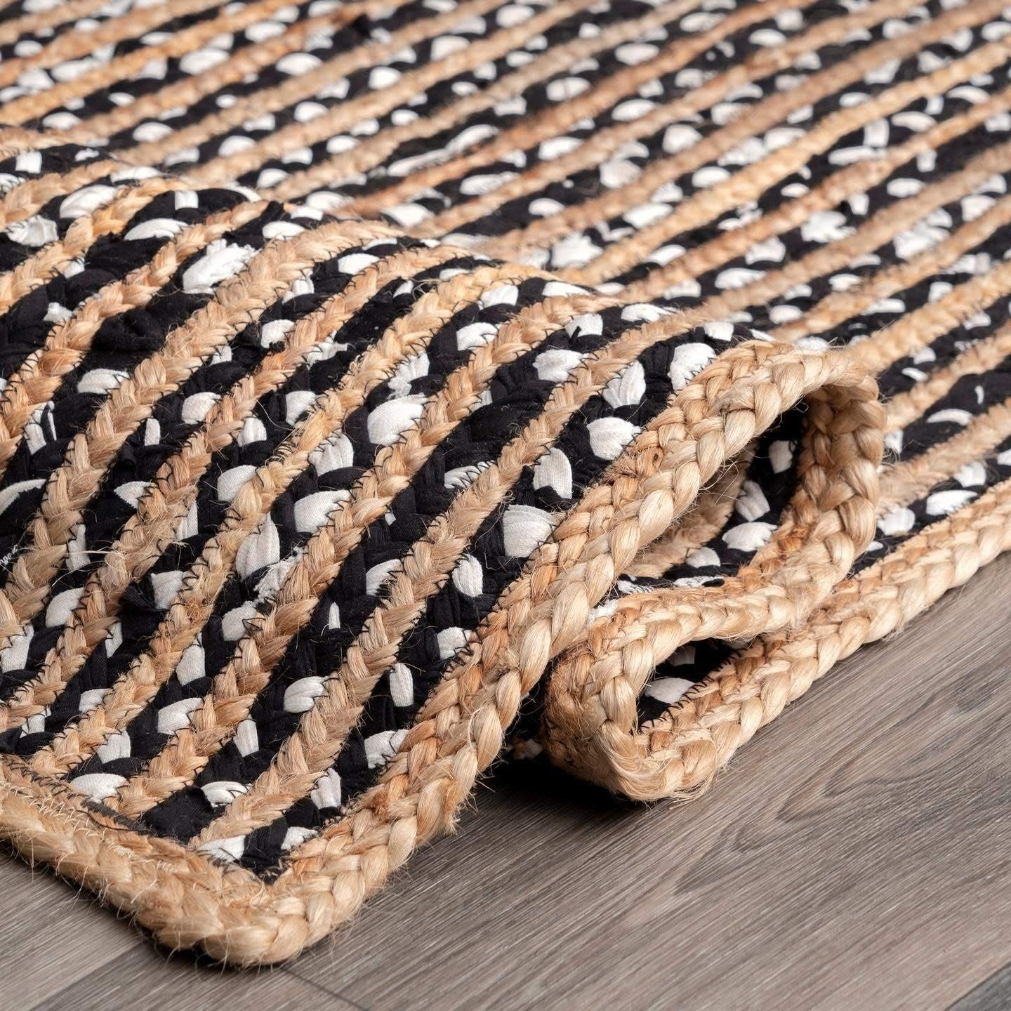 Woven mat with black and white pattern on a wooden floor