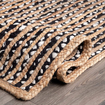 Woven mat with black and white pattern on a wooden floor