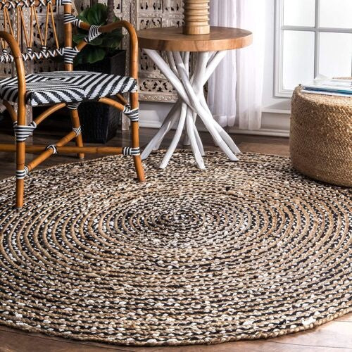 Round woven rug in a room with a chair, table, and window.