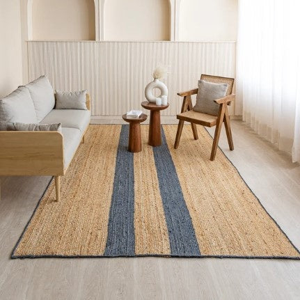 Living room with a striped rug, sofa, chair, and side table.