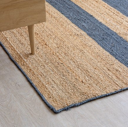 Beige and blue striped rug on a light wooden floor