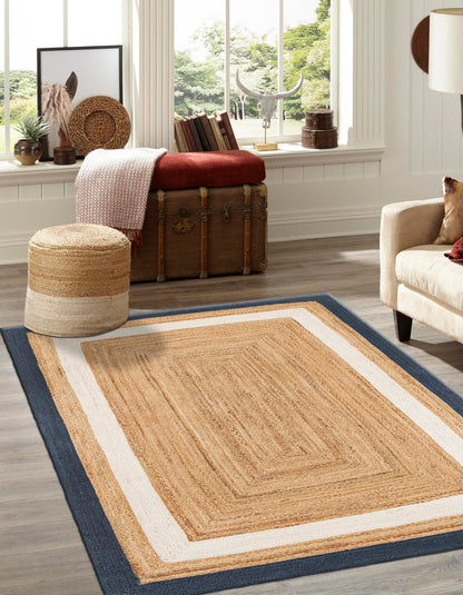 Living room with a jute rug, ottoman, and decor items.