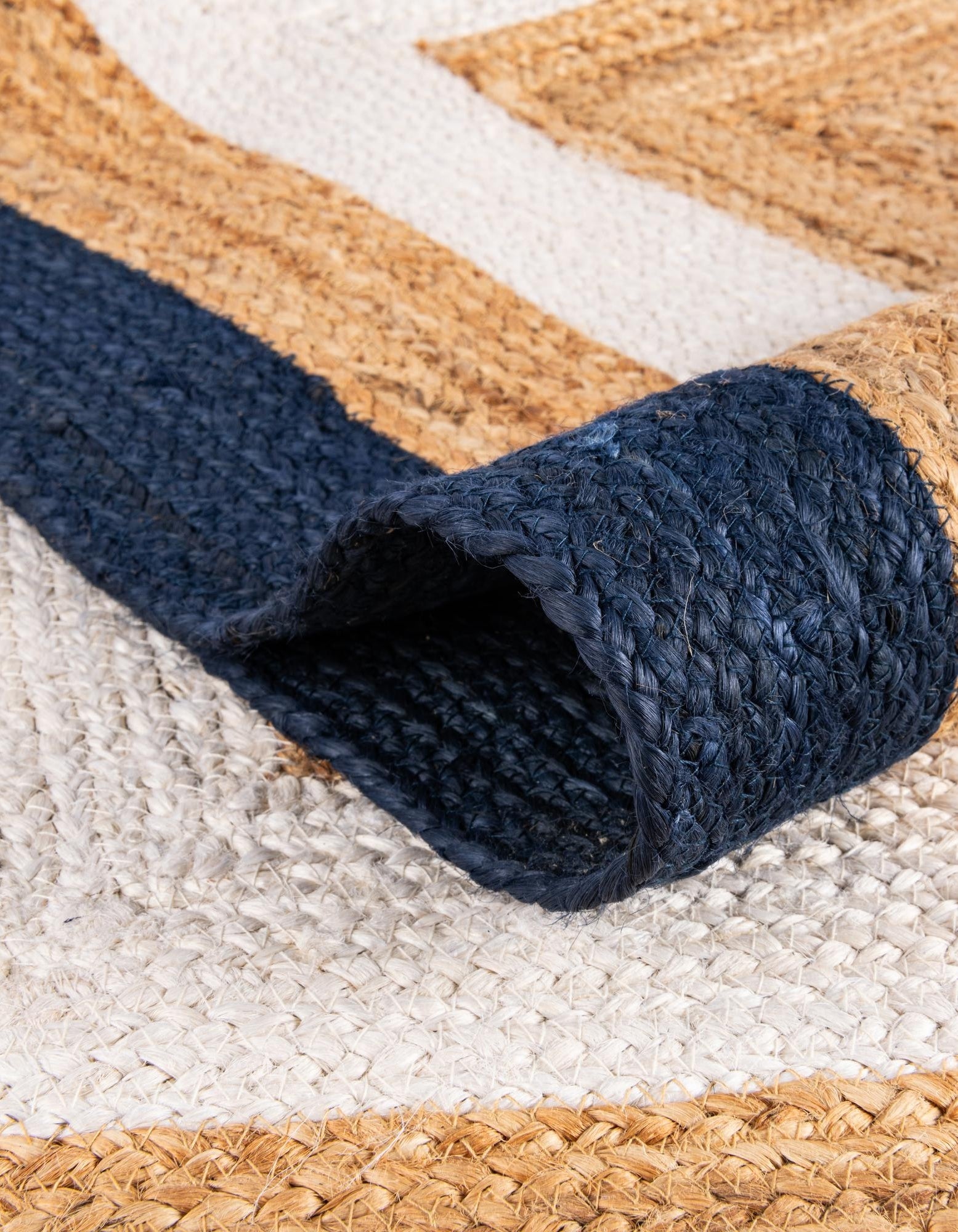 Close-up of a textured blue rug corner on a woven mat with geometric pattern
