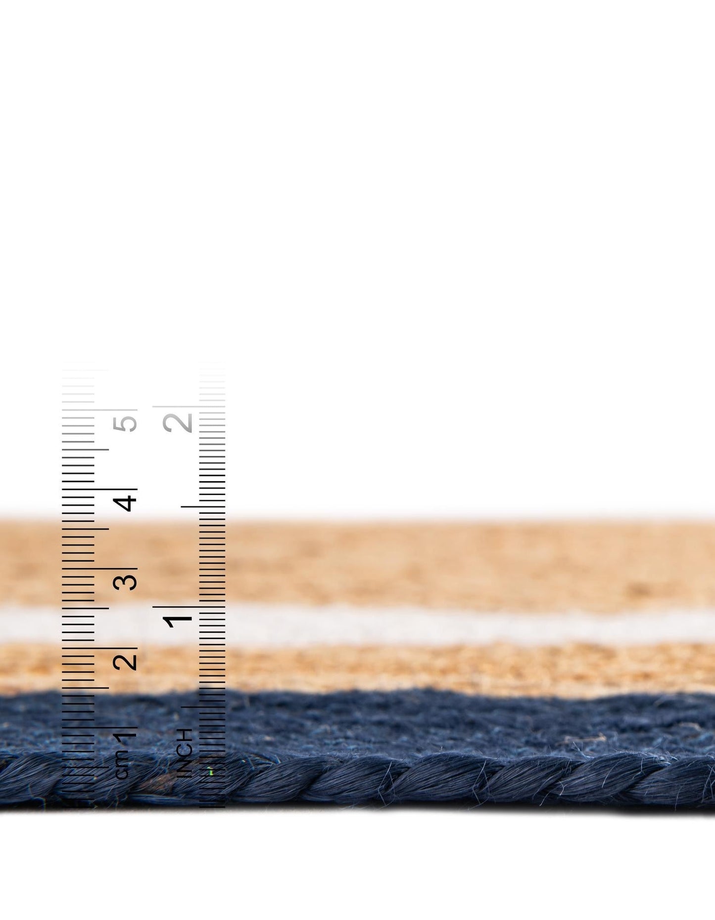 Close-up of a woven mat with a ruler for scale on a white background