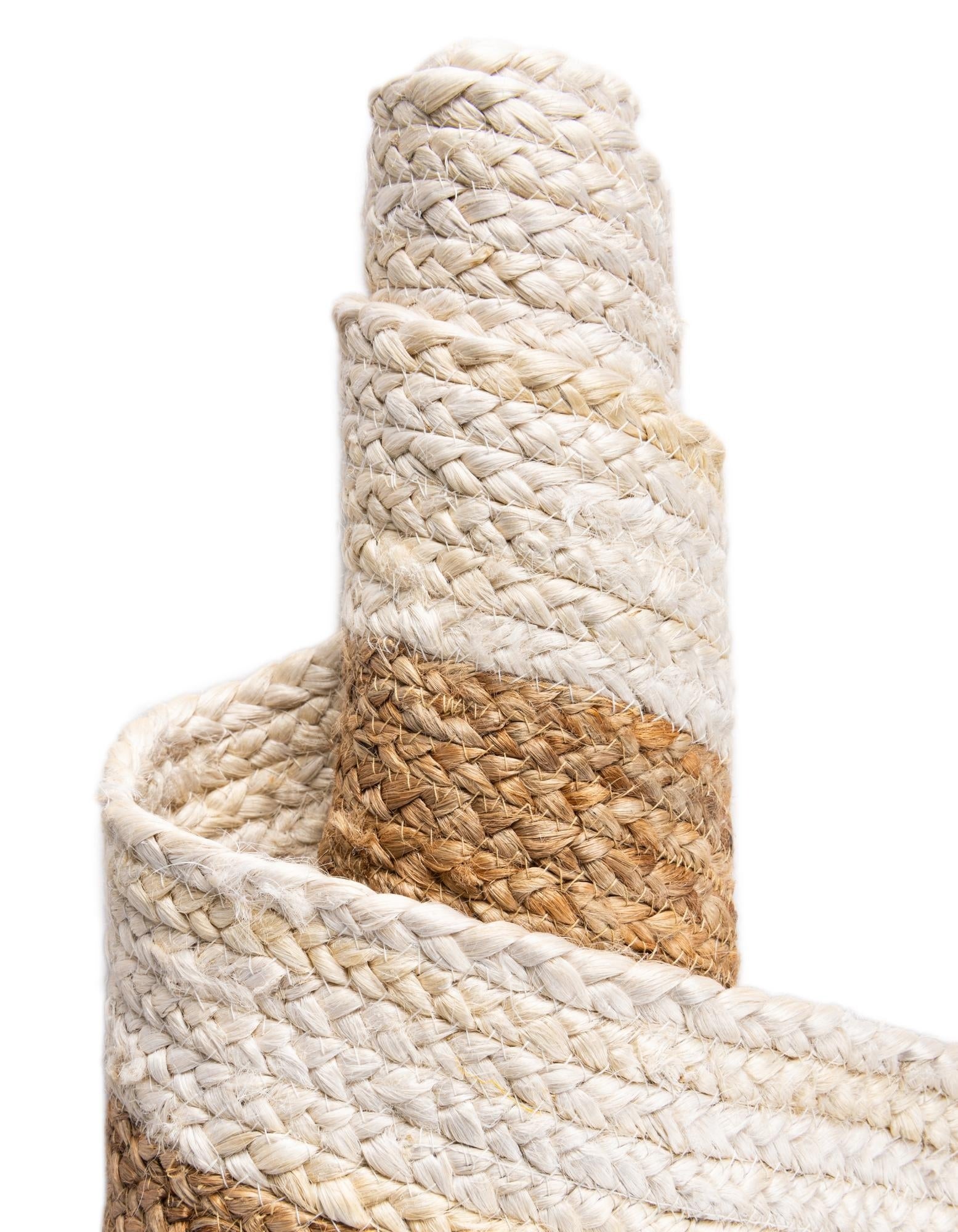 Close-up of a woven rope basket with natural and beige colors on a white background