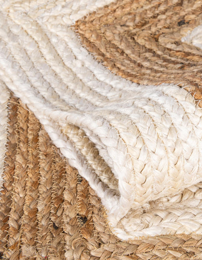 Close-up of a woven jute rug with natural brown and white colors.