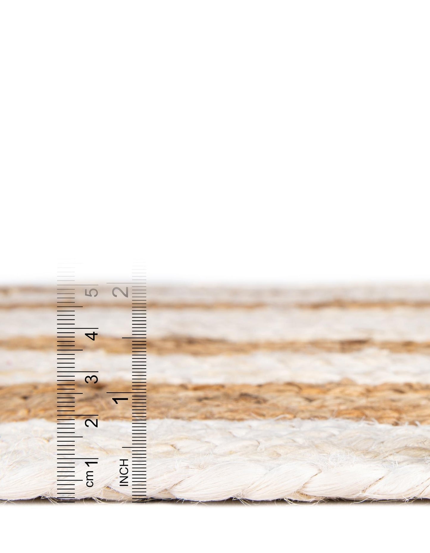 Close-up of braided rope with a ruler for scale on a white background