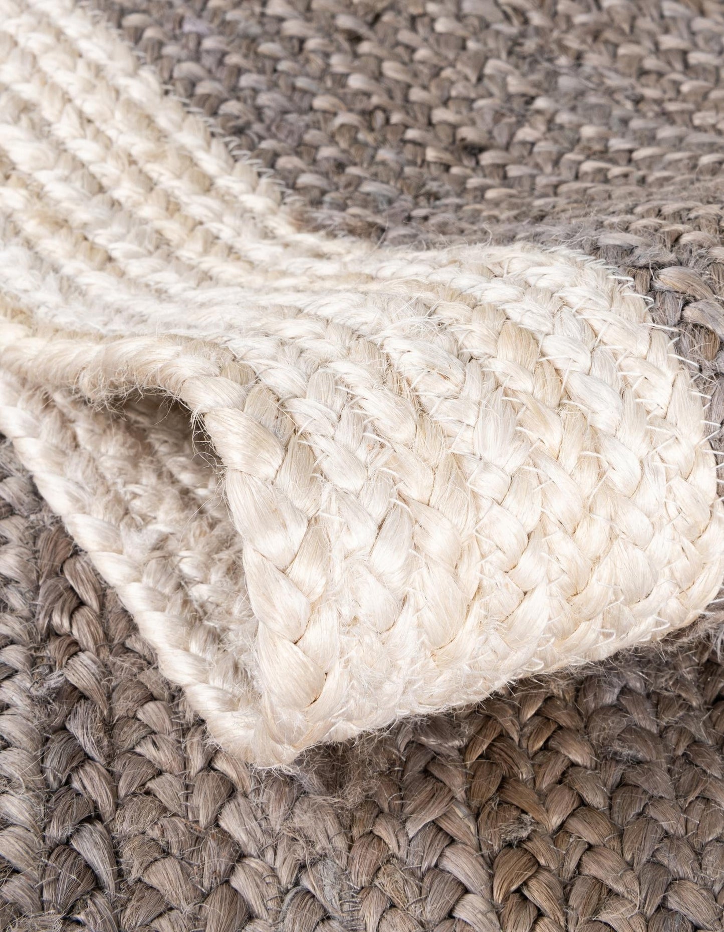 Close-up of a braided beige rug with a textured pattern