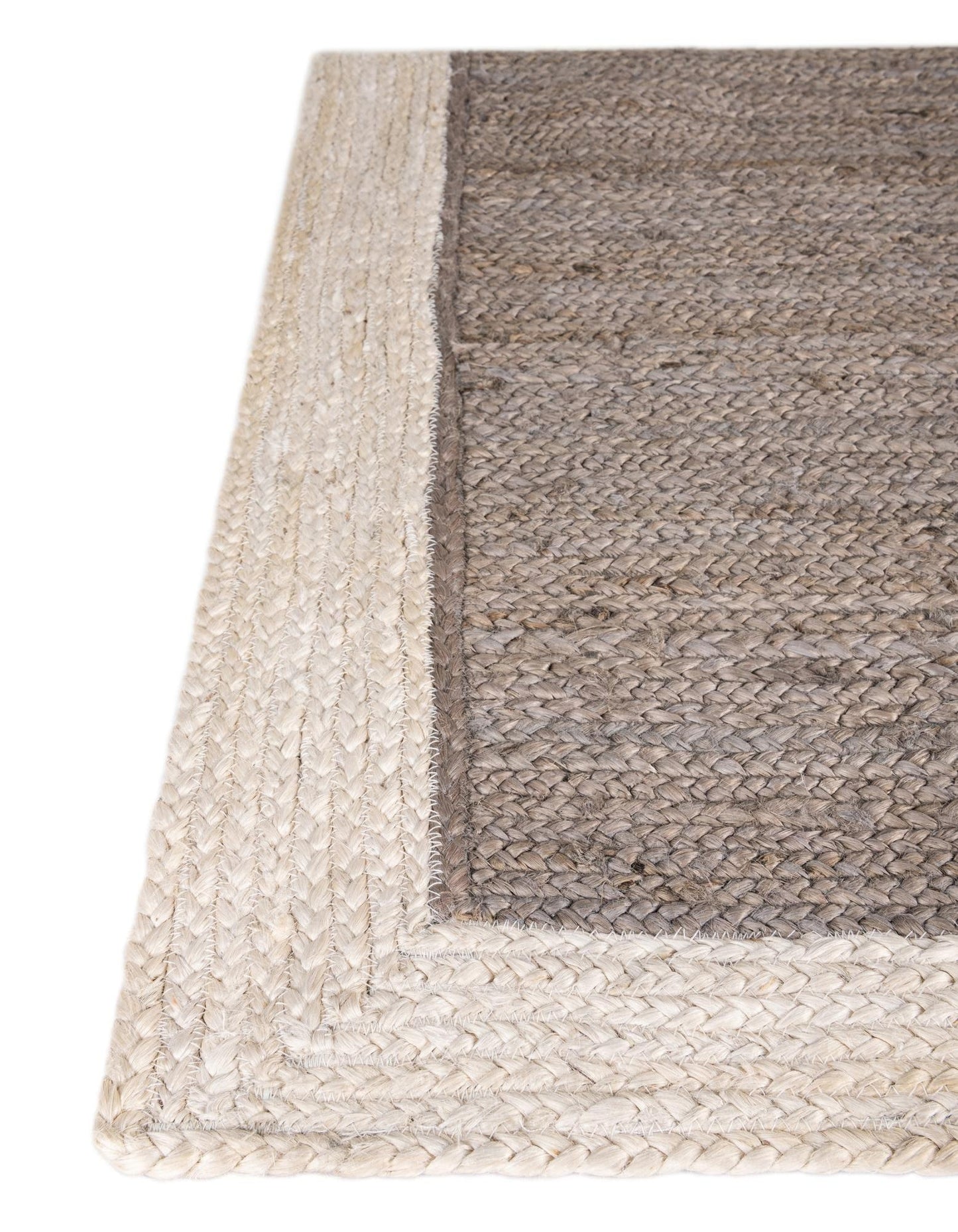 Close-up of a woven rug with a natural fiber border on a white background
