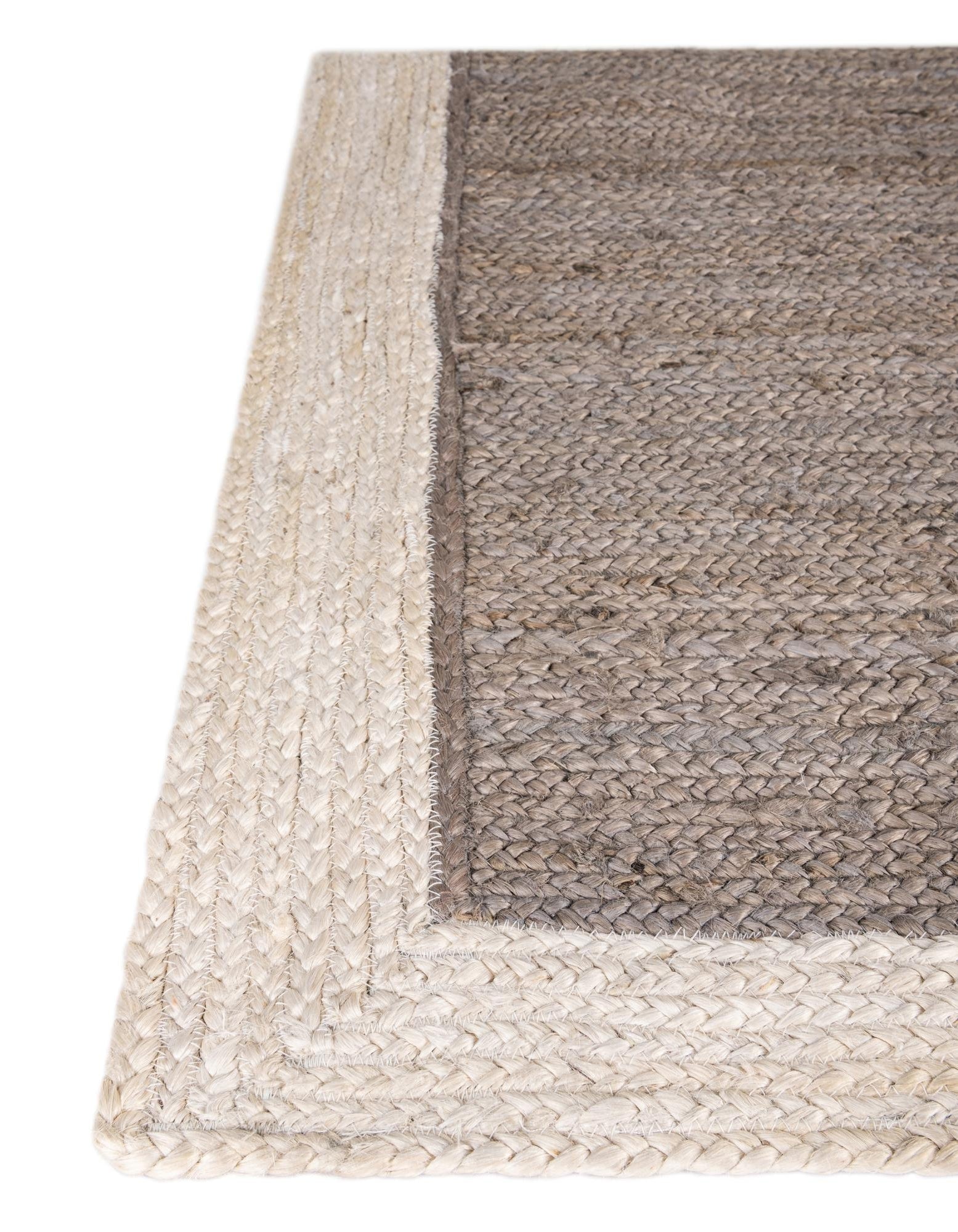Close-up of a woven rug with a natural fiber border on a white background