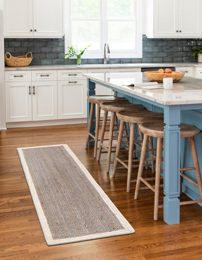 Kitchen with blue island, wooden stools, and a long runner rug on the floor.
