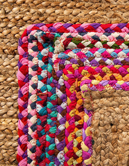 Close-up detail of handwoven natural jute rug with vibrant multicolor braided fabric border and durable textured weave