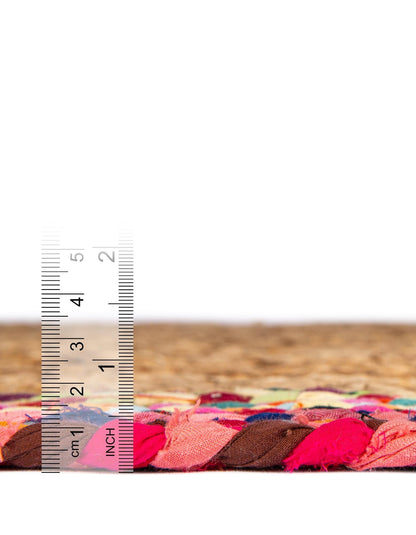 Side profile of handwoven natural jute rug with colorful braided border showing low pile height, durable flatweave texture, and handcrafted boho design