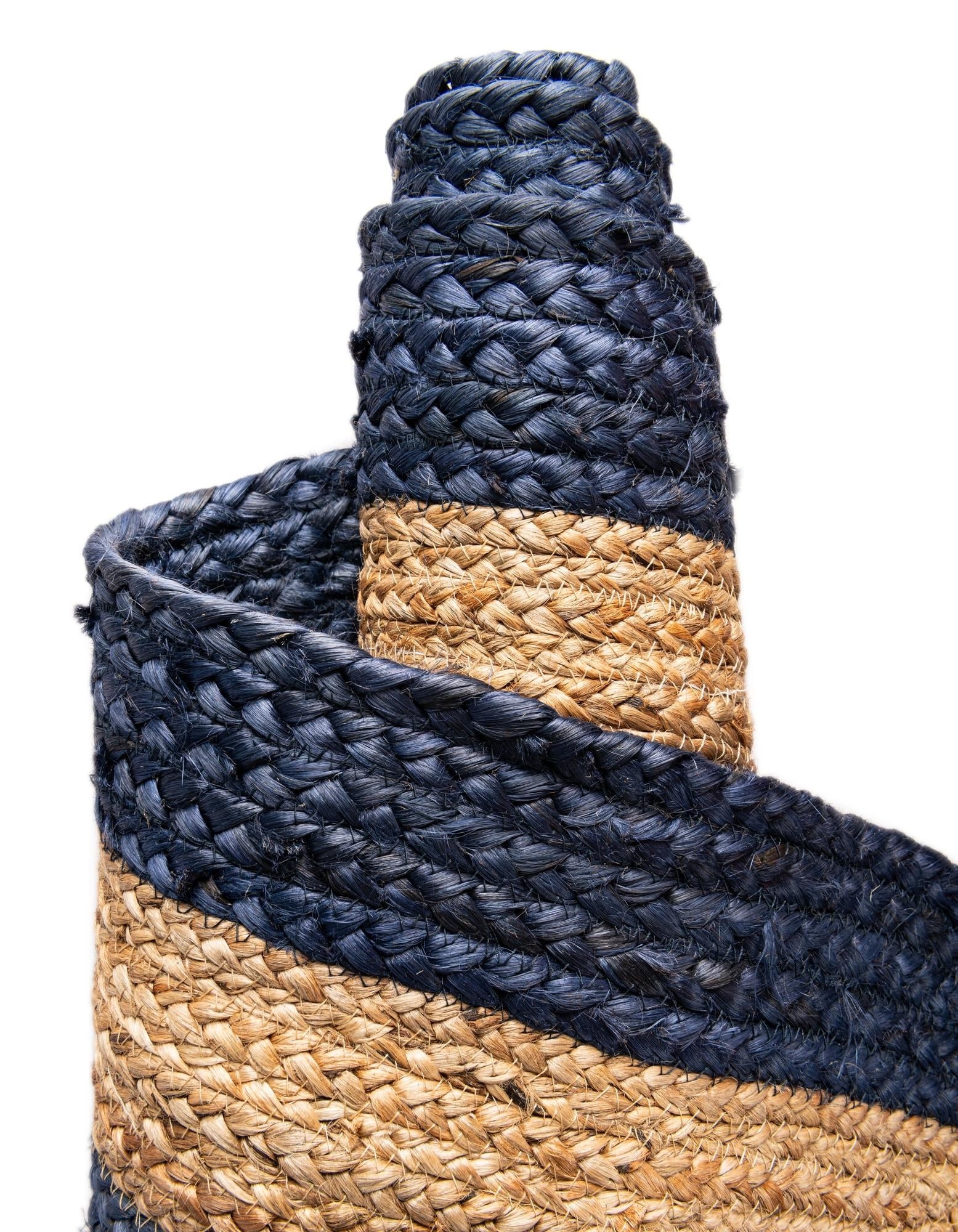 Close-up of a rolled-up blue and beige woven mat on a white background