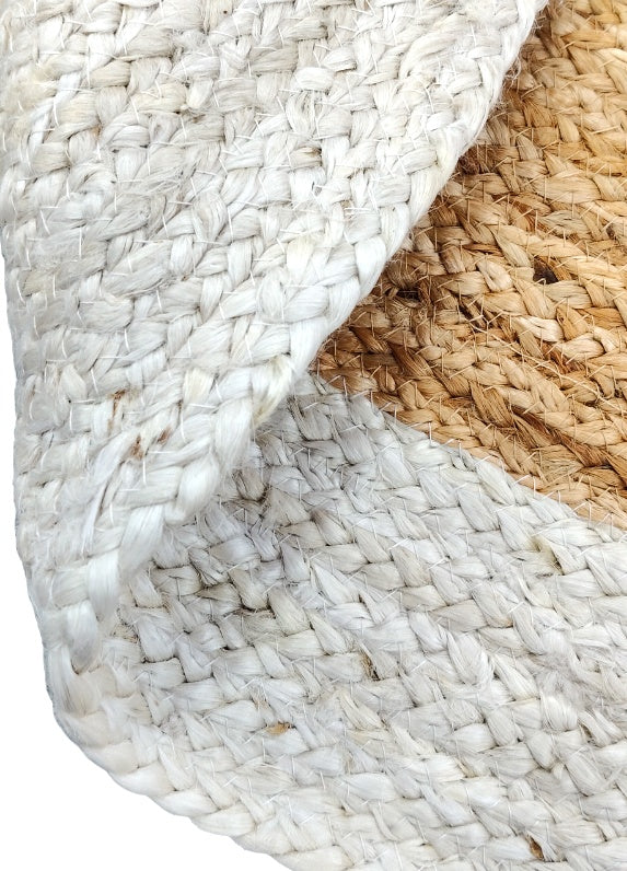 Folded detail of white and natural jute braided rug with thick woven texture and soft handcrafted finish