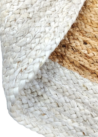 Folded detail of white and natural jute braided rug with thick woven texture and soft handcrafted finish