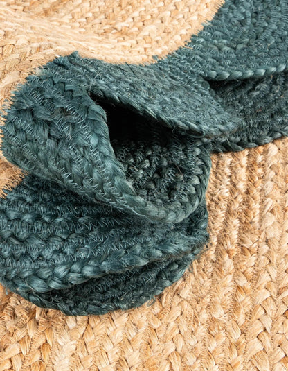 Close-up of natural jute rug with dark green scalloped border, showing thick braided texture and durable handcrafted weave