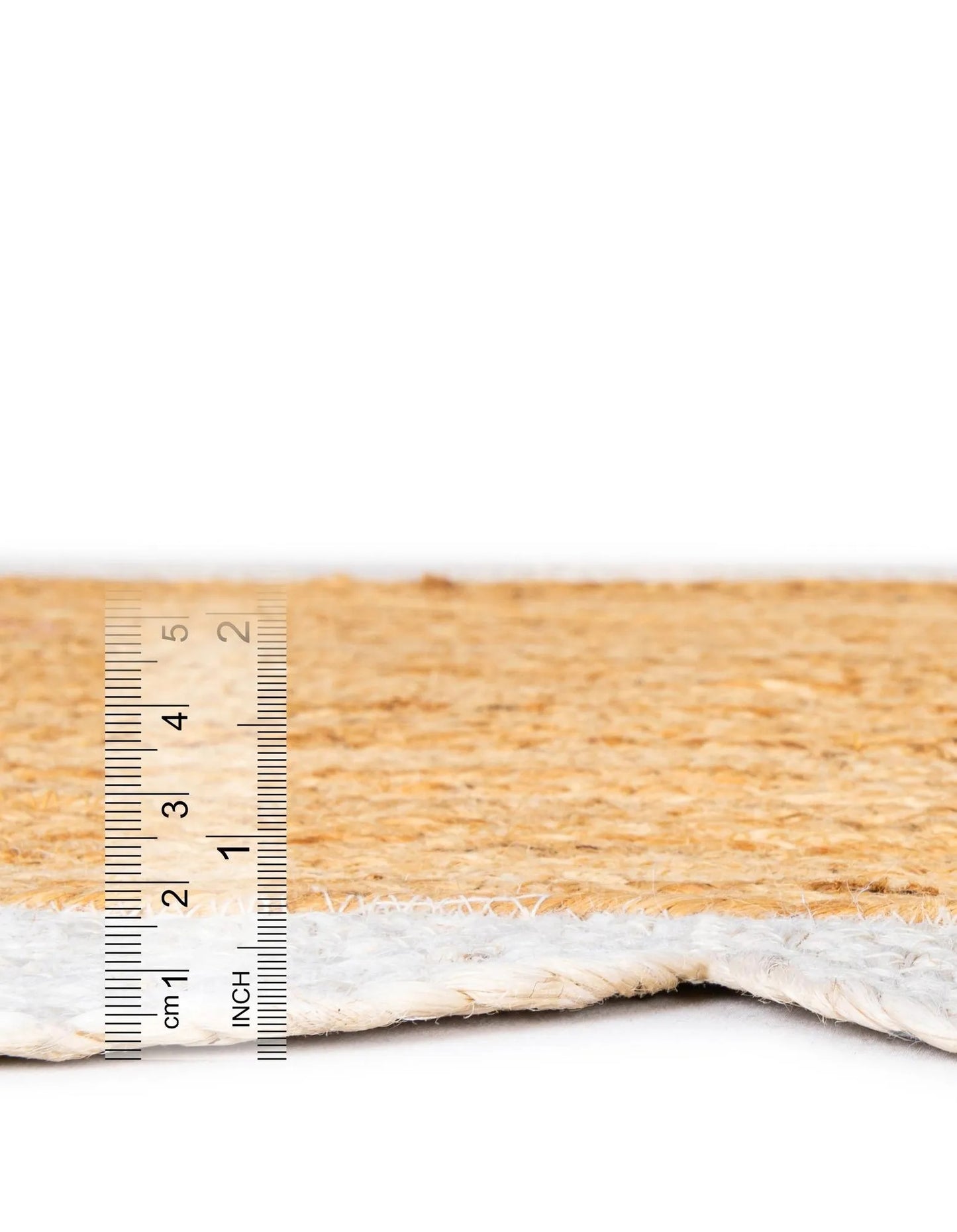 Side profile of handmade jute rug with white scalloped border, low pile flatweave design and sturdy natural fiber construction for long-lasting use