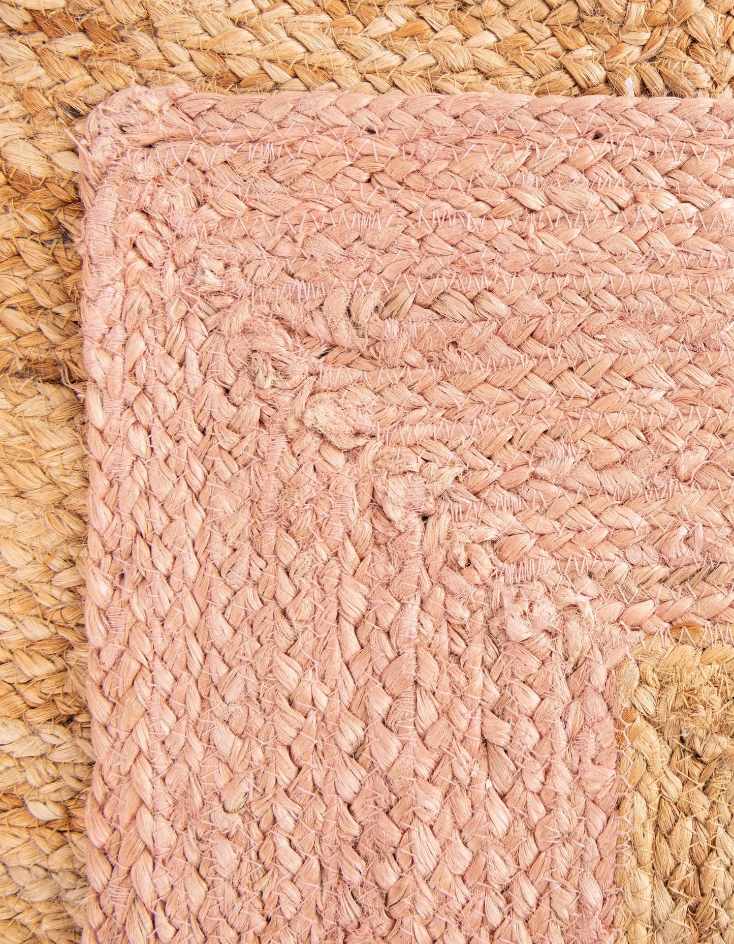 Close-up of a pink woven mat on a textured surface