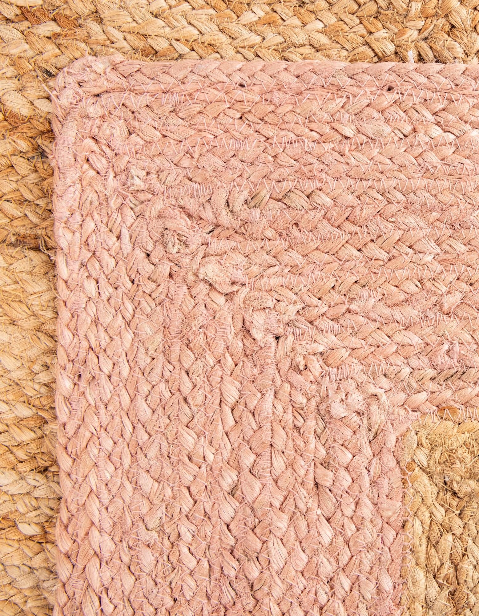 Close-up of a pink woven mat on a textured surface