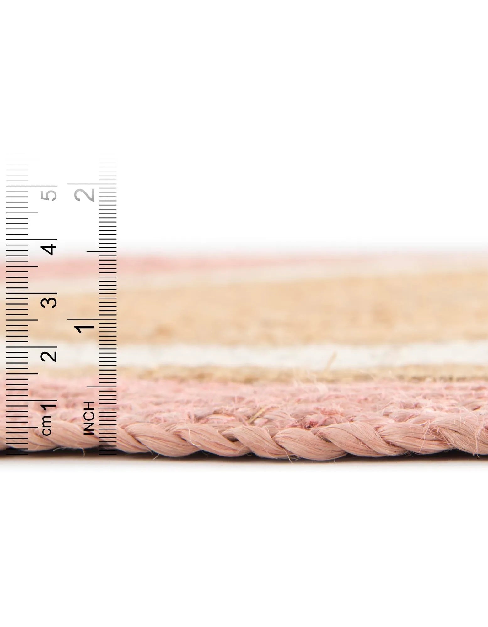 Close-up of pink braided cable with a ruler for scale on a white background