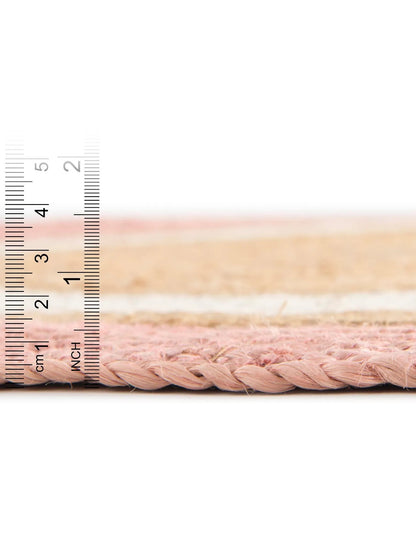 Close-up of pink braided cable with a ruler for scale on a white background