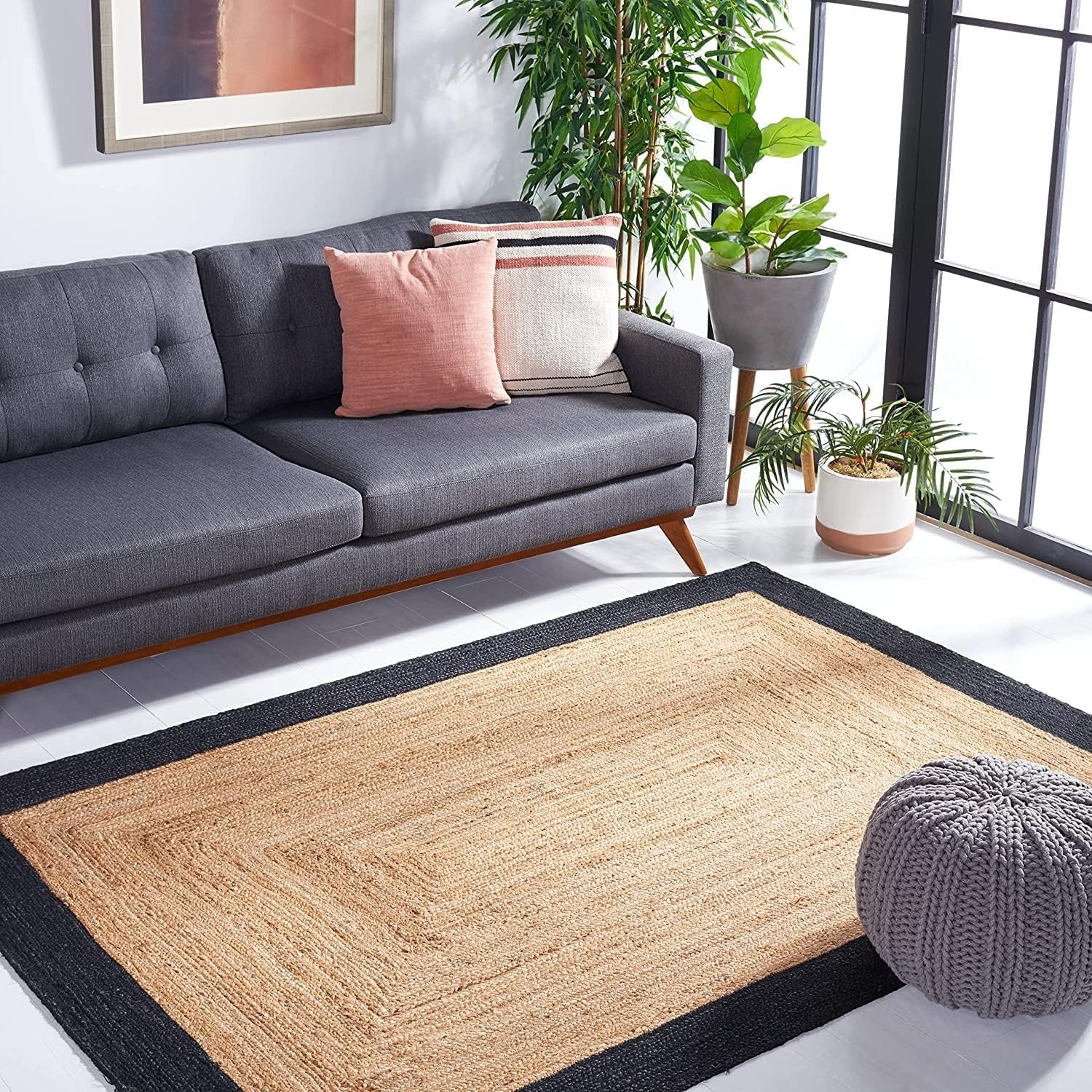 Living room with a gray sofa, decorative pillows, and a woven area rug.