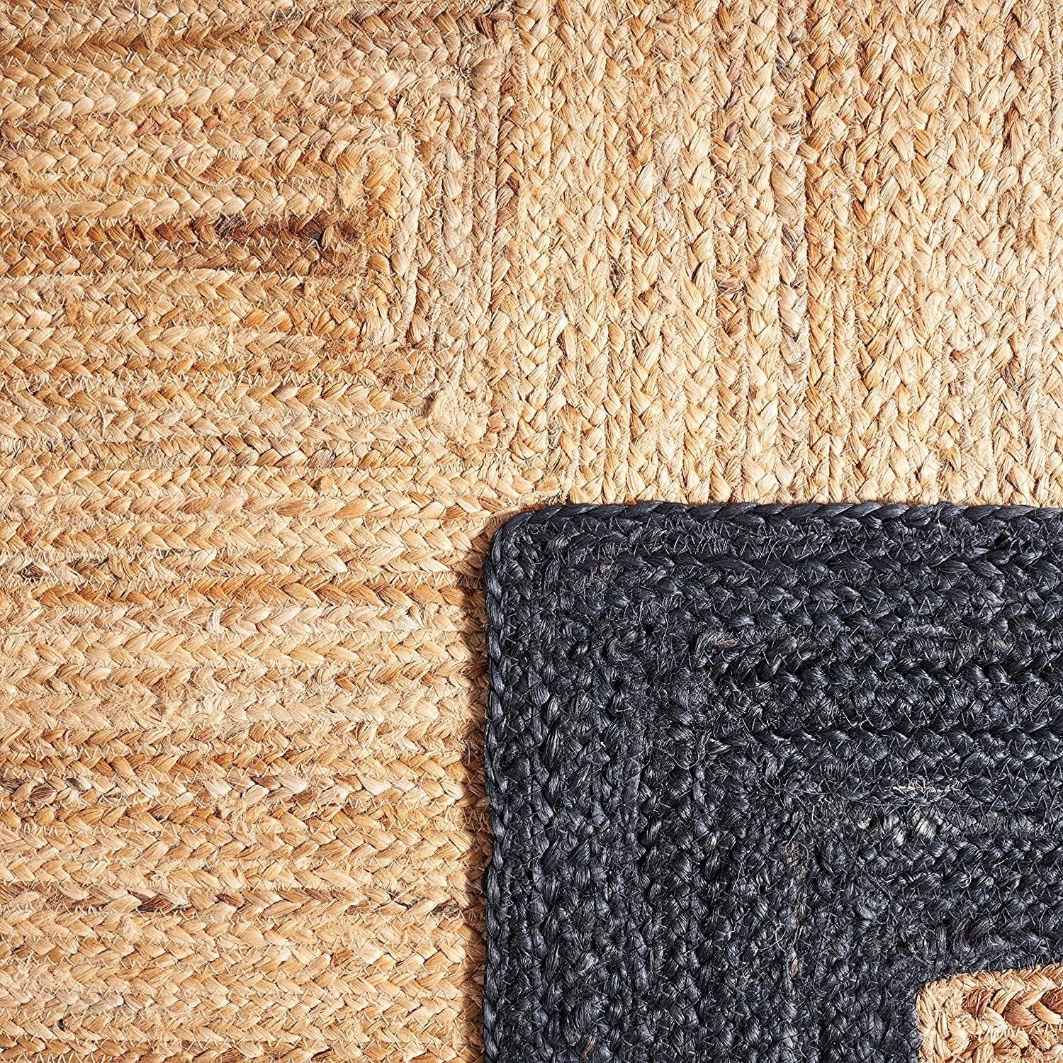 Close-up of a textured beige rug and a dark gray rug corner.